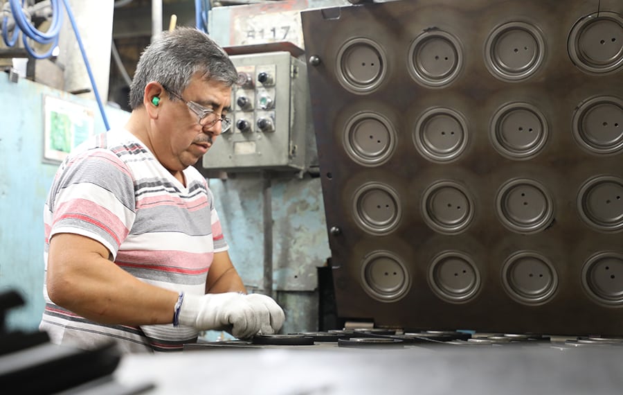 A man standing in front of a molding machine