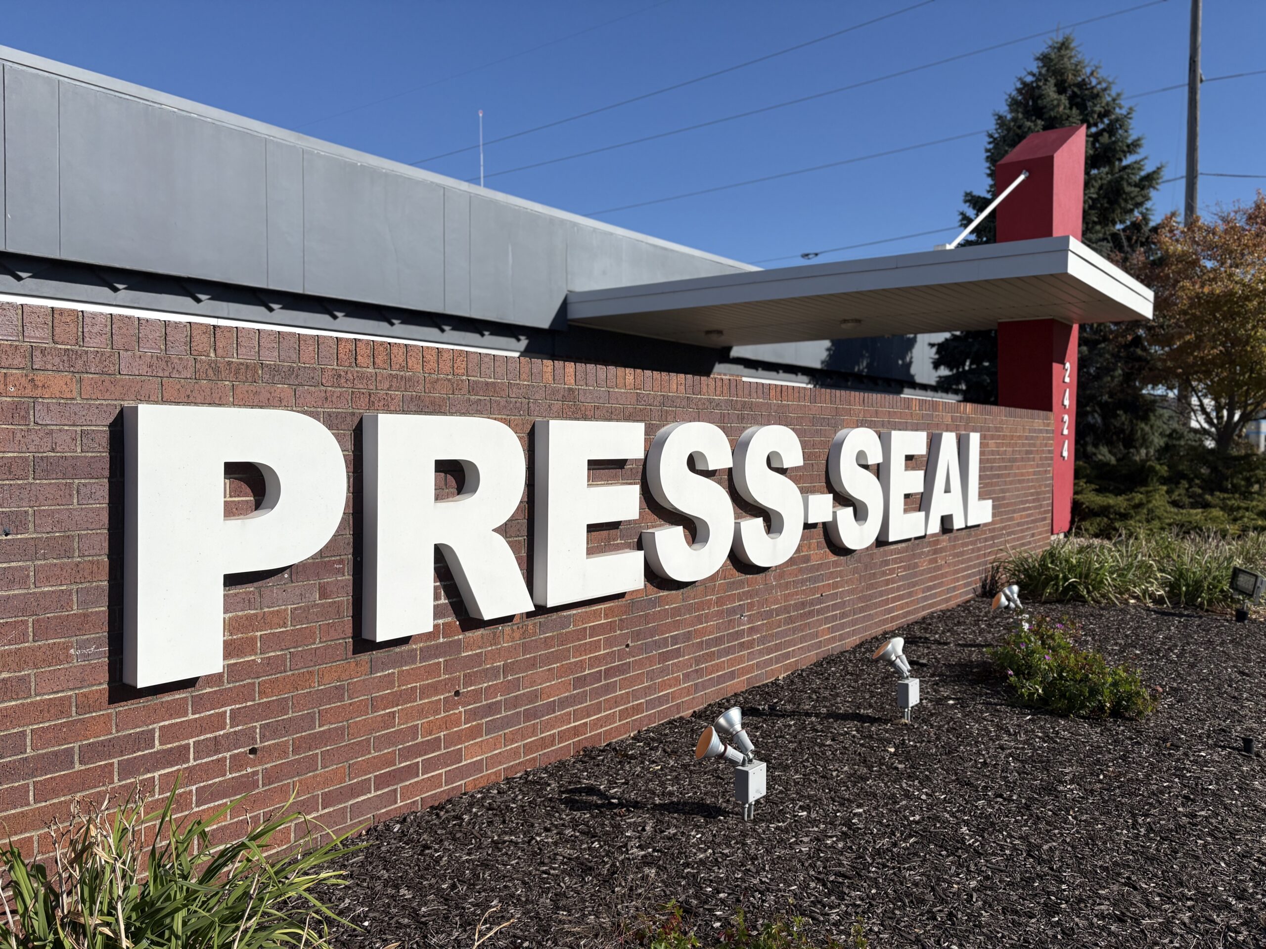 Press-Seal entrance Brick wall with the words Press-Seal